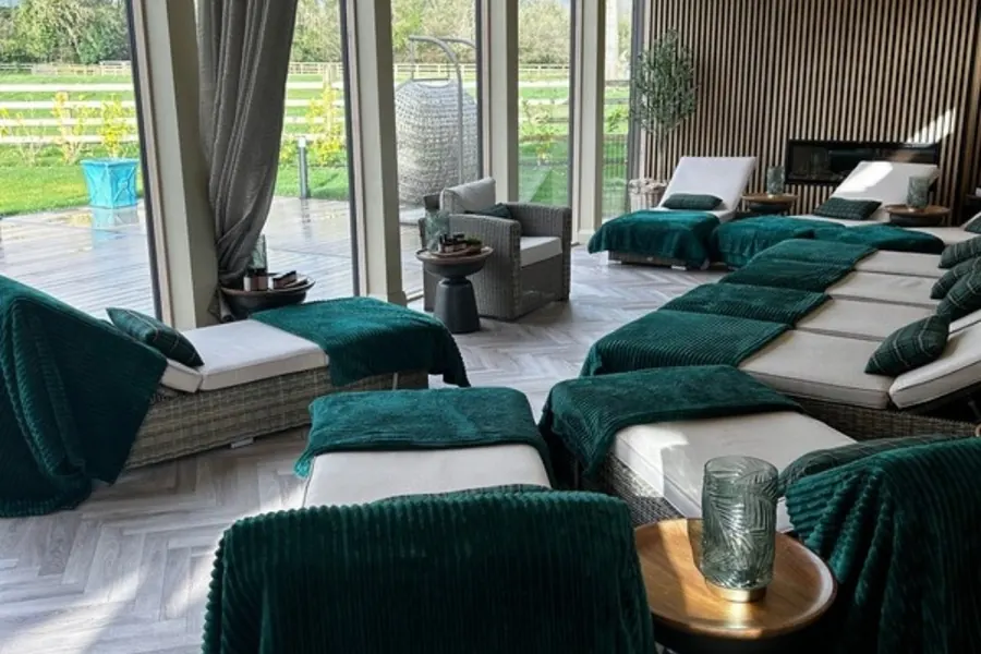 The relaxation room at Revas Spa with green loungers and garden views